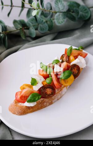 Bruschetta italienne traditionnelle avec tomates cerises et feuilles de basilic Banque D'Images