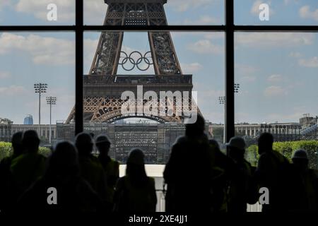 Paris, France. 25 juin 2024. Les gens regardent le stade de la Tour Eiffel, qui accueillera le Beach volley pendant les Jeux Olympiques de Paris 2024 et le Football aveugle pendant les Jeux Paralympiques de Paris 2024, à Paris, France, le 25 juin 2024. Crédit : Julien Mattia/Xinhua/Alamy Live News Banque D'Images