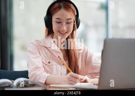 Jeune étudiant collage utilisant un ordinateur et un appareil mobile étudiant en ligne. Banque D'Images