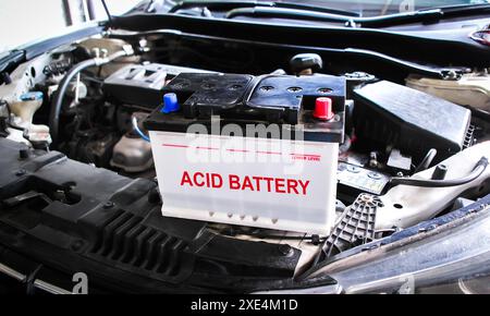 Batterie ACIDE pour voiture sur le compartiment moteur d'une voiture , concept d'entretien de batterie de voiture Banque D'Images