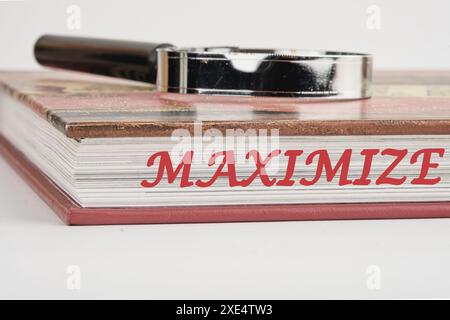 MAXIMISEZ le texte à la fin du livre avec une loupe sur le dessus sur un fond blanc Banque D'Images