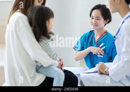 Infirmière en uniforme interagissant avec un patient souriant Banque D'Images