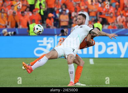 Berlin, Allemagne. 25 juin 2024. Marko Arnautovic, d’Autriche (l), se bat pour un ballon avec Stefan de Vrij, des pays-Bas, lors de leur match en phase de groupes de l’UEFA EURO 2024 à l’Olympiastadion de Berlin. Crédit : Oleksandr Prykhodko/Alamy Live News Banque D'Images