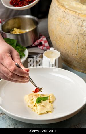 Pâtes fraîches avec sauce dans une roue entière de parmesan Banque D'Images