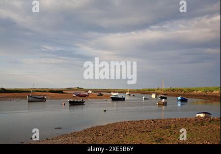 Une vue de la marée Overy Creek avec de petits bateaux à la Staithe sur la côte nord du Norfolk à Burnham Overy Staithe, Norfolk, Angleterre, Royaume-Uni. Banque D'Images