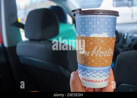 Calgary, Alberta, Canada. 2 février 2024. Quelqu'un profitant d'une tasse de café Tim Hortons au milieu de la saison des fêtes de décembre. Banque D'Images