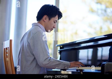 Homme japonais jouant du piano Banque D'Images