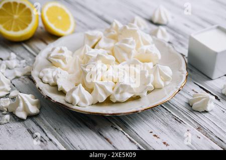 Biscuits meringue dans une assiette sur bois Banque D'Images