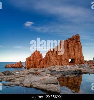 Vue des roches rouges d'Arbatax avec des reflets dans les bassins de marée au premier plan Banque D'Images