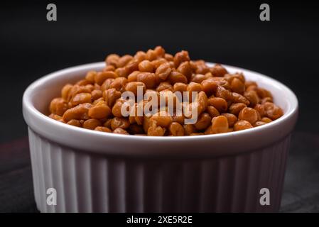 Délicieuses lentilles en conserve saines dans un bol blanc nervuré en céramique Banque D'Images