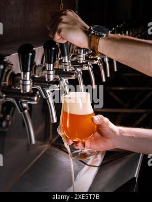 Barman versant de la bière fraîche dans un verre dans un pub Banque D'Images