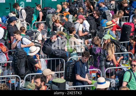 Les fêtards arrivent à la gare de Castle Cary alors qu'ils sortent de la plate-forme et prennent les bus qui les fermeront vers Glastonbury Festival à Worthy Farm dans le Somerset. Date de la photo : mercredi 26 juin 2024. Banque D'Images