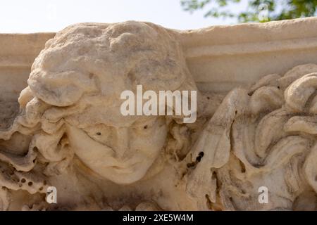 Un gros plan d'une belle tête de méduse en pierre sculptée dans le musée de l'ancienne ville en ruine de Hiérapolis à Türkiye par une journée ensoleillée avec un ciel bleu. Banque D'Images