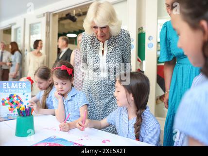 La reine Camilla rend visite à une classe d'accueil et entend parler de l'initiative de lecture 'Shepherd and Sheep', qui attribue les nouveaux élèves de la réception à un élève de 6e année, qui agit comme une amie et un modèle tout au long des nouveaux élèves de première année à l'école, lors de sa visite à Christ Church C of E Primary School à Londres. Date de la photo : mercredi 26 juin 2024. Banque D'Images