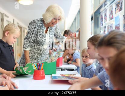 La reine Camilla rend visite à une classe d'accueil et entend parler de l'initiative de lecture 'Shepherd and Sheep', qui attribue les nouveaux élèves de la réception à un élève de 6e année, qui agit comme une amie et un modèle tout au long des nouveaux élèves de première année à l'école, lors de sa visite à Christ Church C of E Primary School à Londres. Date de la photo : mercredi 26 juin 2024. Banque D'Images