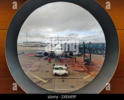 Vue depuis une fenêtre ronde d'un avion sur le tarmac, aéroport international de Keflavik, Islande â€‹ Banque D'Images