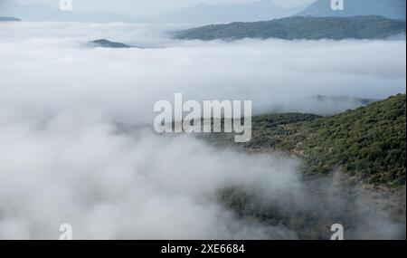 Sommets des montagnes couverts d'une couche de brume et de brouillard à l'aube. Paysage naturel Banque D'Images