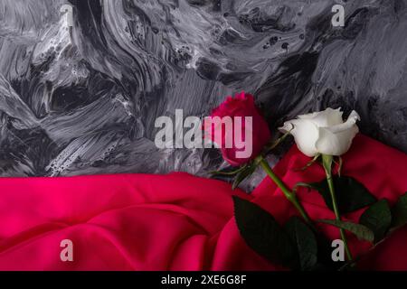 Contraste de roses délicates sur un fond tourbillon gris dramatique. Banque D'Images