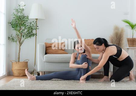 Instructeur de yoga aidant les élèves à faire des poses de yoga dans le studio, concept de classe de yoga Banque D'Images