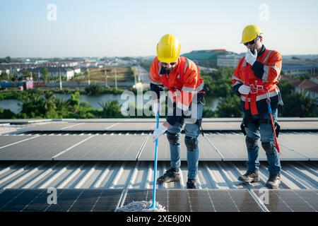 Ingénieur et technicien travaillant sur le panneau solaire sur le toit de l'entrepôt pour inspecter les panneaux solaires qui ont été en fonctionnement Banque D'Images