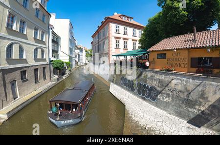 Prague, République tchèque - 27 mai 2019 : un bateau rempli de touristes navigue sur le canal Certovka à Prague par une journée ensoleillée Banque D'Images