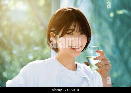 Jeune femme avaler de l'eau dans l'étonnement Banque D'Images