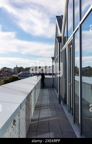 Quelqu'un regardant la vue sur Brighton depuis le balcon du bureau au dernier étage. Circus Street, Brighton, Royaume-Uni. Architecte : Shedkm, 2022. Banque D'Images