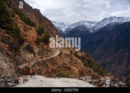 Début du trek de la vallée du Langtang avec des randonneurs suivant la route vers les montagnes enneigées de l'Himalaya, Népal, Asie Copyright : CasparxSchlagete Banque D'Images