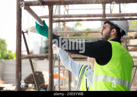 Ingénieur et architecte travaillant sur le chantier de construction, revérifiant les plans et le processus. Banque D'Images