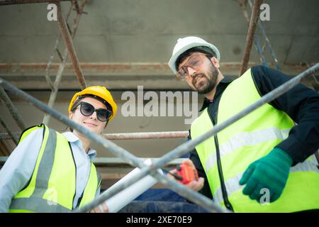 Ingénieur et architecte travaillant sur le chantier de construction, revérifiant les plans et le processus. Banque D'Images