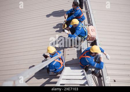 Les travailleurs sur un chantier de construction prennent une pause sur le toit d'un bâtiment. Banque D'Images