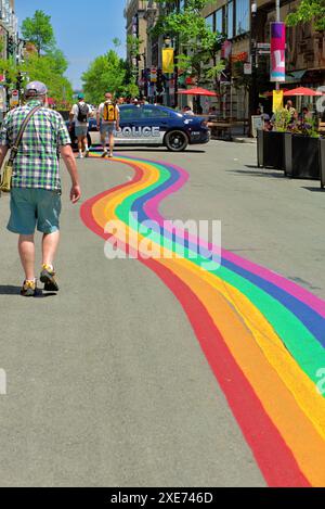 Piétons marchant le long d'un sentier couleur arc-en-ciel dans le village LGBTQ de Montréal situé sur Sainte-Catherine est Banque D'Images