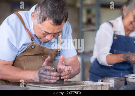 Portrait d'un couple asiatique senior faisant des activités ensemble dans l'atelier de poterie. Banque D'Images