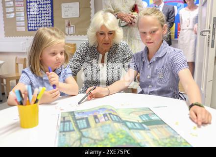 La reine Camilla rend visite à une classe d'accueil et entend parler de l'initiative de lecture 'Shepherd and Sheep', qui attribue les nouveaux élèves de la réception à un élève de 6e année, qui agit comme une amie et un modèle tout au long des nouveaux élèves de première année à l'école, lors de sa visite à Christ Church C of E Primary School à Londres. Date de la photo : mercredi 26 juin 2024. Banque D'Images