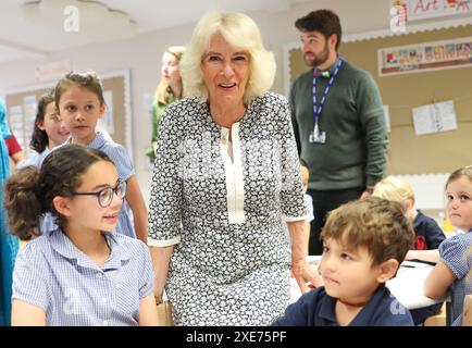 La reine Camilla rend visite à une classe d'accueil et entend parler de l'initiative de lecture 'Shepherd and Sheep', qui attribue les nouveaux élèves de la réception à un élève de 6e année, qui agit comme une amie et un modèle tout au long des nouveaux élèves de première année à l'école, lors de sa visite à Christ Church C of E Primary School à Londres. Date de la photo : mercredi 26 juin 2024. Banque D'Images