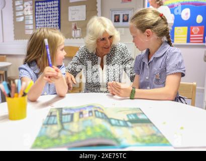 La reine Camilla rend visite à une classe d'accueil et entend parler de l'initiative de lecture 'Shepherd and Sheep', qui attribue les nouveaux élèves de la réception à un élève de 6e année, qui agit comme une amie et un modèle tout au long des nouveaux élèves de première année à l'école, lors de sa visite à Christ Church C of E Primary School à Londres. Date de la photo : mercredi 26 juin 2024. Banque D'Images