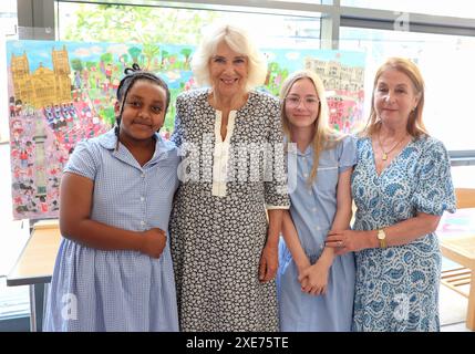 La reine Camilla rend visite à une classe d'accueil et entend parler de l'initiative de lecture 'Shepherd and Sheep', qui attribue les nouveaux élèves de la réception à un élève de 6e année, qui agit comme une amie et un modèle tout au long des nouveaux élèves de première année à l'école, lors de sa visite à Christ Church C of E Primary School à Londres. Date de la photo : mercredi 26 juin 2024. Banque D'Images