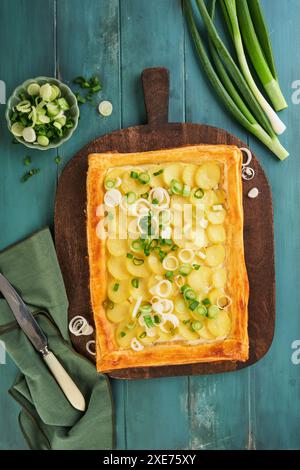 Tarte à pâte feuilletée maison ou galette avec pommes de terre, fromage à la crème et romarin sur fond de table en bois ancien. Plat traditionnel britannique plat maison o Banque D'Images