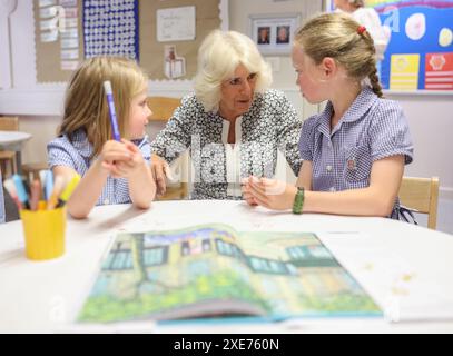 La reine Camilla rend visite à une classe d'accueil et entend parler de l'initiative de lecture 'Shepherd and Sheep', qui attribue les nouveaux élèves de la réception à un élève de 6e année, qui agit comme une amie et un modèle tout au long des nouveaux élèves de première année à l'école, lors de sa visite à Christ Church C of E Primary School à Londres. Date de la photo : mercredi 26 juin 2024. Banque D'Images