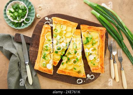 Tarte à pâte feuilletée maison ou galette avec pommes de terre, fromage à la crème et romarin sur fond de table sombre en pierre ancienne. Plat traditionnel britannique fait maison di Banque D'Images