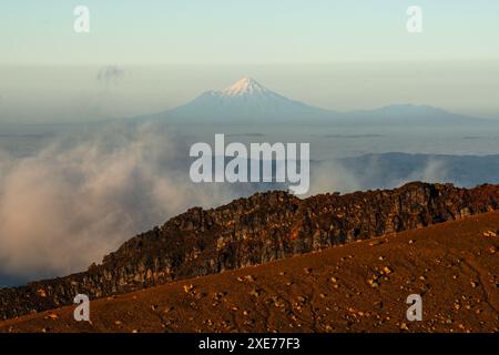 Vue du paysage volcanique sur le volcan Taranaki lointain, vue depuis le parc national de Tongariro, site du patrimoine mondial de l'UNESCO, Île du Nord, Nouvelle-Zélande Banque D'Images