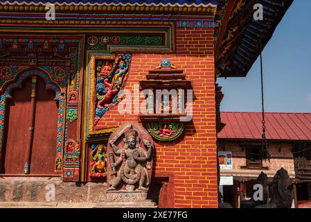 Détails de la pierre hindoue colorée et sculpture sur bois sur les murs du plus ancien temple hindou du Népal consacré à Vishnu, Changu Narayan, Népal Banque D'Images