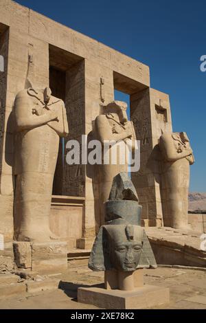 Granit tête de Ramsès II devant les statues d'Osiris, Ramesseum, Temple mémorial du Pharaon Ramsès II, 13ème siècle av. J.-C., Thèbes antiques, Louxor Banque D'Images