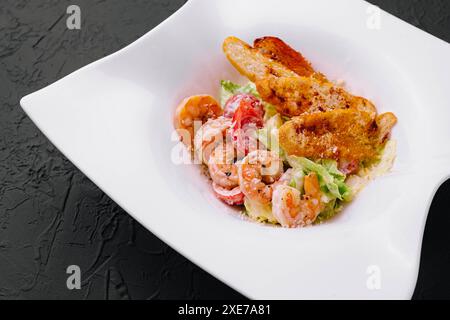 Salade de laitue avec sauce César, crevettes tigrées, fromage et chapelure Banque D'Images