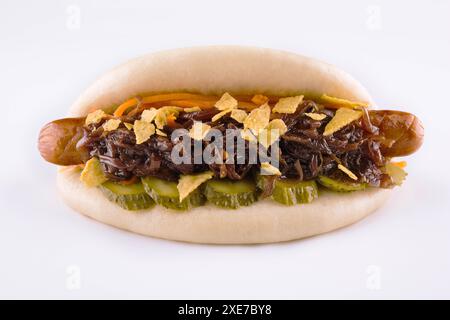 Hot dog avec concombres marinés et oignons croustillants sur fond blanc Banque D'Images