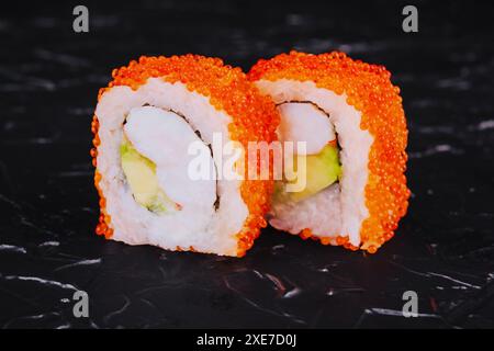 Rouleau de sushi aux crevettes, fromage d'avocat et caviar tobiko Banque D'Images