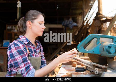 Portrait d'une menuisière travaillant dans son atelier au comptoir Banque D'Images