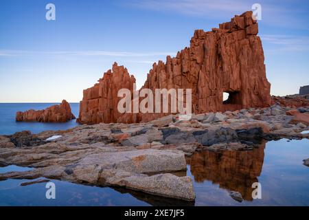 Vue des roches rouges d'Arbatax avec des reflets dans les bassins de marée au premier plan Banque D'Images