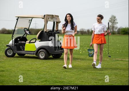 Femme active posant avec un équipement de golf près du véhicule à l'extérieur Banque D'Images