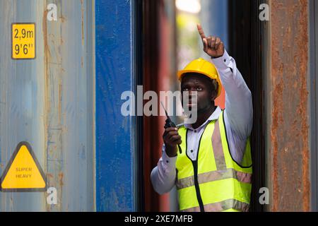 Portrait d'un travailleur masculin tenant un talkie-walkie devant le conteneur Banque D'Images